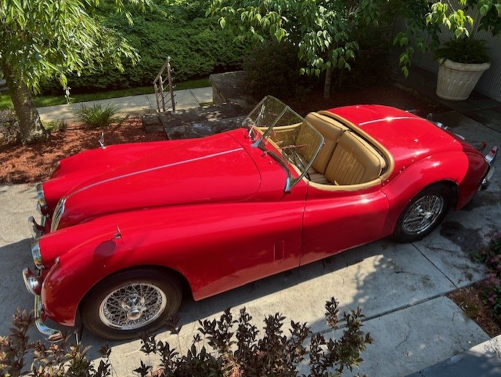 1956 Jaguar XK 140 Roadster side profile showing biscuit leather interior and convertible top